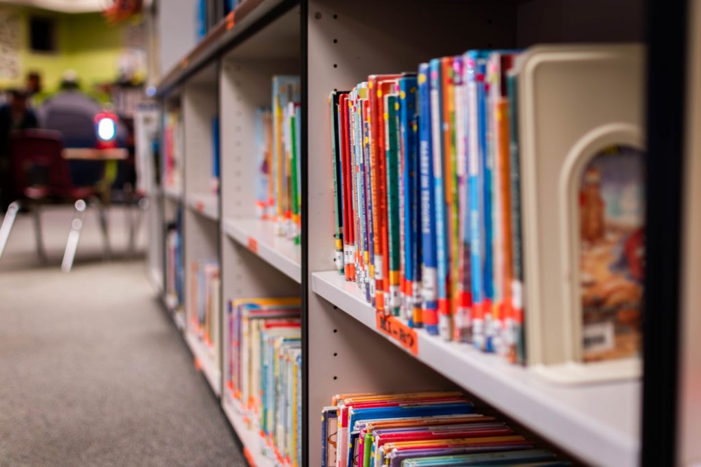 Books in neat rows fill the shelves of an elementary school library.