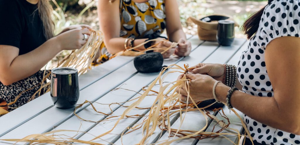 Females weaving baskets on the craft workshop. Hands holding the craftwork, close up shot