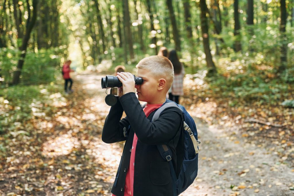 Discovering new places. Kids in green forest at summer daytime together