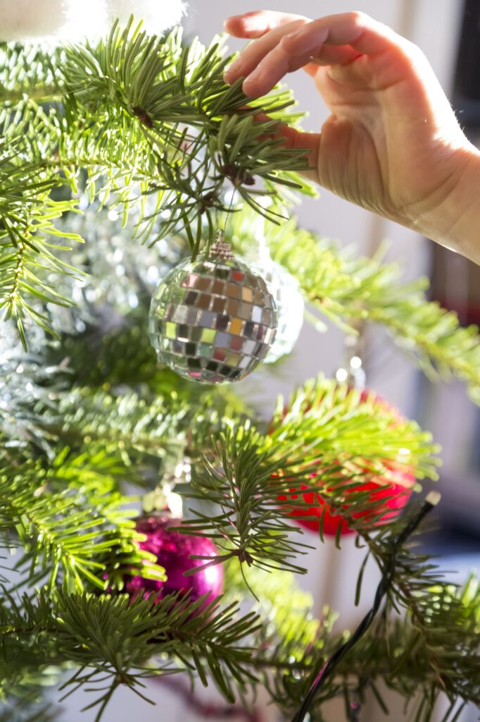 Hand of girl decorating Christmas tree