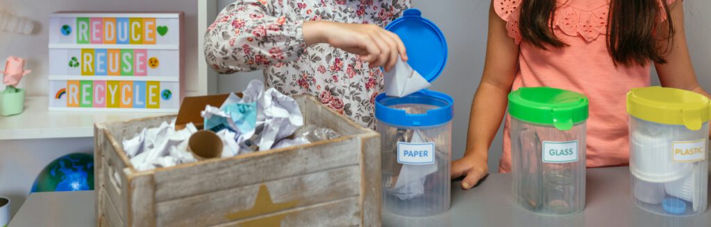 Student recycling cardboard on selective trash bin in ecology classroom
